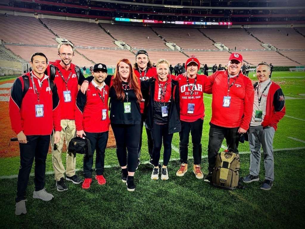 The Utah Athletics digital & creative team and the athletics communications team of full-timers and student assistants celebrating the Pac-12 Championship. L to R: Nick Gruet, Ryan Gallant, Chris Frkovich, Jordie Lindley, Jeff Guckert, Sarah Ramundt, Forrest Gmitro, Kade Sybrowsky, Paul Kirk.